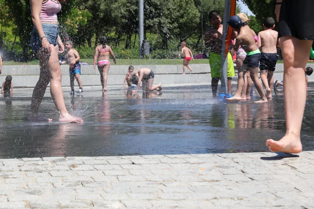Varias personas, entre ellas ni&ntilde;os, se refrescan en los chorros de Madrid R&iacute;o un d&iacute;a antes de que, seg&uacute;n la Agencia Estatal de Meteorolog&iacute;a (AEMET), llegue a la pen&iacute;nsula Ib&eacute;rica y a las Islas Baleares la primera ola de calor del verano 2019.