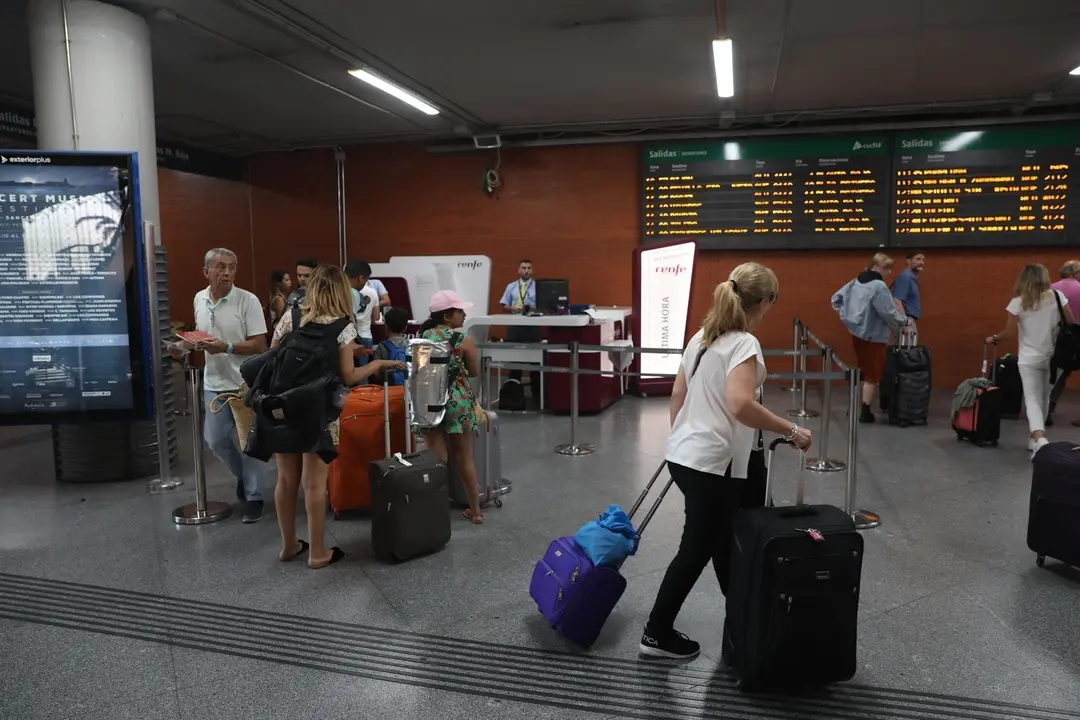 Varios pasajeros se aproximan a una oficina de venta de billetes de &uacute;ltima hora en la estaci&oacute;n de tren Puerta de Atocha de Madrid durante la primera de las cuatro jornadas de paros parciales de Renfe a los que el sindicato CGT ha convocado a los trabajado
