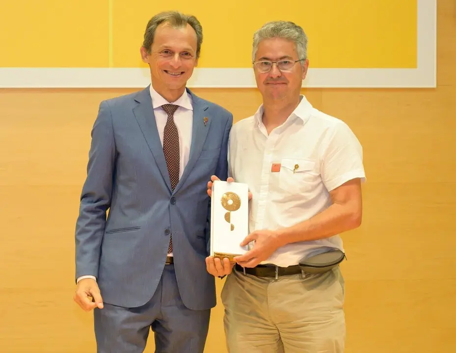 El ministro, Pedro Duque, en el momento de la entrega a Enrique Mart&iacute;nez, director cient&iacute;fico del proyecto Mar&iacute;a de Maeztu, investigador del IFCA. Foto del Ministerio de Ciencia, Innovaci&oacute;n y Universidades.