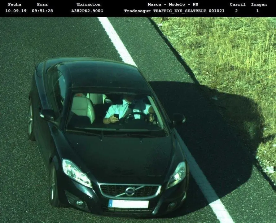 Un conductor manipula su tel&eacute;fono m&oacute;vil mientras conduce. Se trata de una infracci&oacute;n grave que conlleva la p&eacute;rdida de 3 puntos del carnet y 200 euros de multa