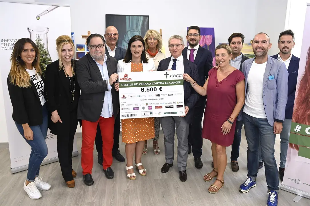 Entrega a la AECC del cheque con la recaudaci&oacute;n del desfile de verano