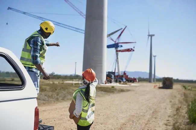 focused_211790148-stock-photo-engineers-dirt-road-wind-turbine
