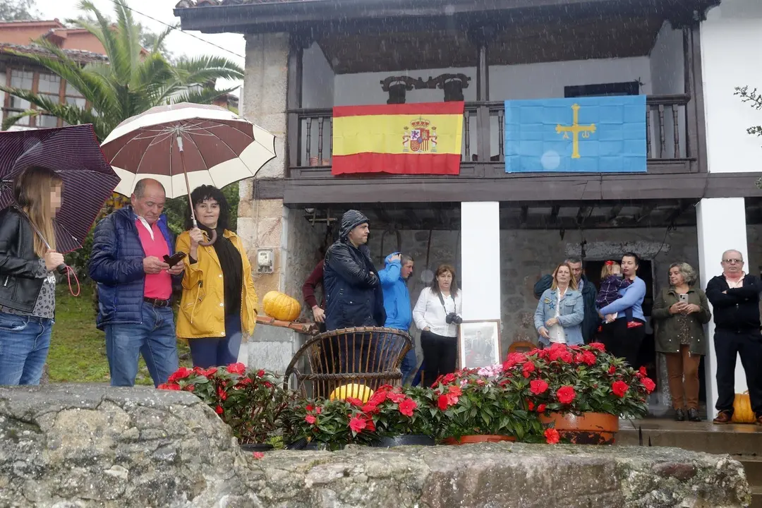 Varias personas con paraguas por la lluvia esperando la llegada de la Familia Real a Asiego, pueblo ejemplar de Asturias 2019, en Asturias (Espa&ntilde;a) el 19 de octubre.