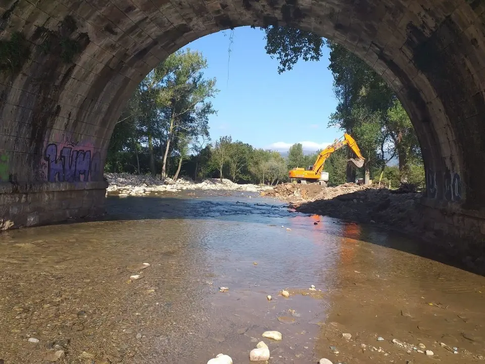 M&aacute;quinas trabajando en las escolleras del r&iacute;o Bisue&ntilde;a en las inmediaciones de B&aacute;rcena de Pie de Concha