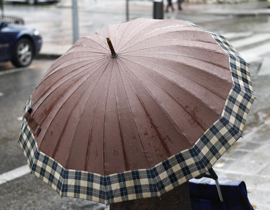 Una mujer pasea bajo su paraguas por Madrid.