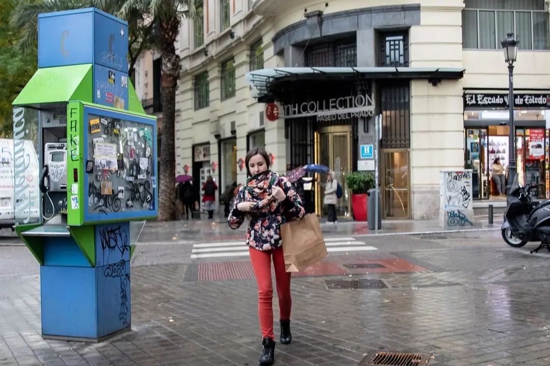 Una chica pasea por la calle abrigada con bufanda y abrigo durante el peor temporal del oto&ntilde;o del 2019 en Espa&ntilde;a en el que se ver&aacute;n afectadas 37 provincias avisadas por viento, nieve, oleaje o lluvia, en Madrid (Espa&ntilde;a),  a 14 de noviembre de 2019.