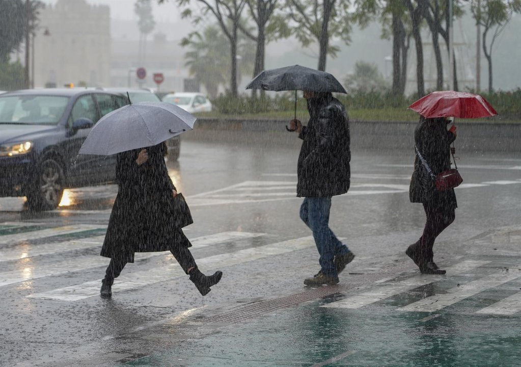 Peatones bajo la lluvia en Sevilla (Imagen de archivo)
