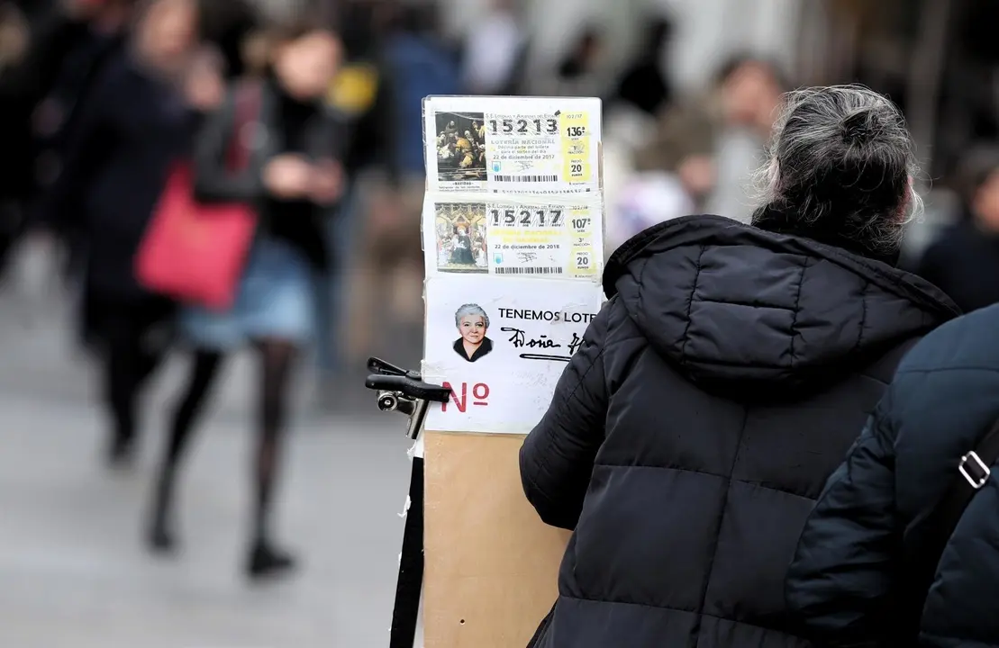 Una lotera junto a su puesto de venta de boletos de Loter&iacute;a de Navidad en la Plaza del Sol de Madrid (Espa&ntilde;a), a 16 de diciembre de 2019 .