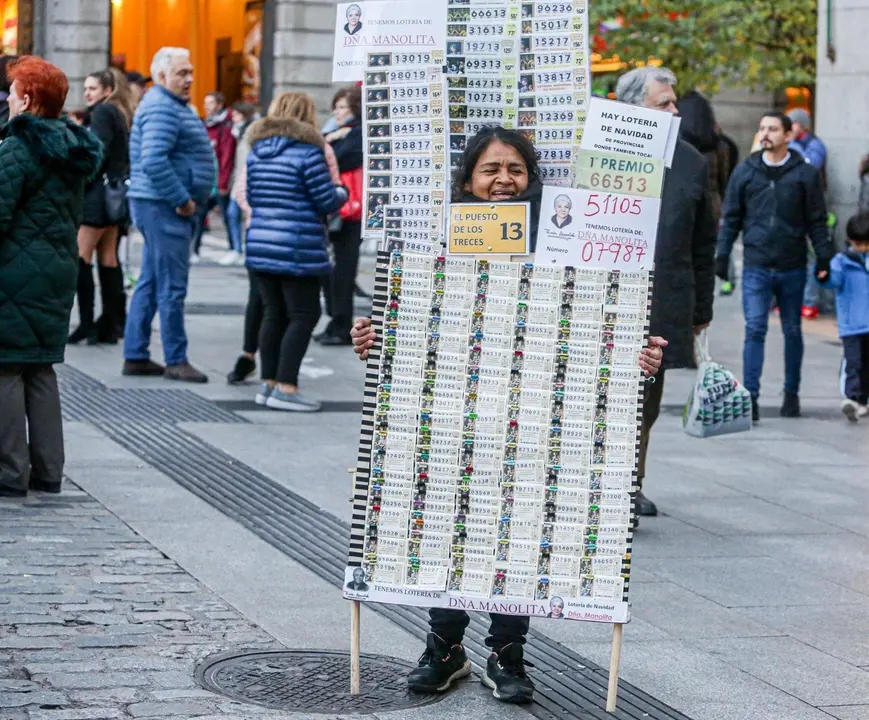 Una mujer vende d&eacute;cimos de Loter&iacute;a de Navidad de la Administraci&oacute;n de Do&ntilde;a Manolita, en Madrid (Espa&ntilde;a), a 18 de noviembre de 2019.