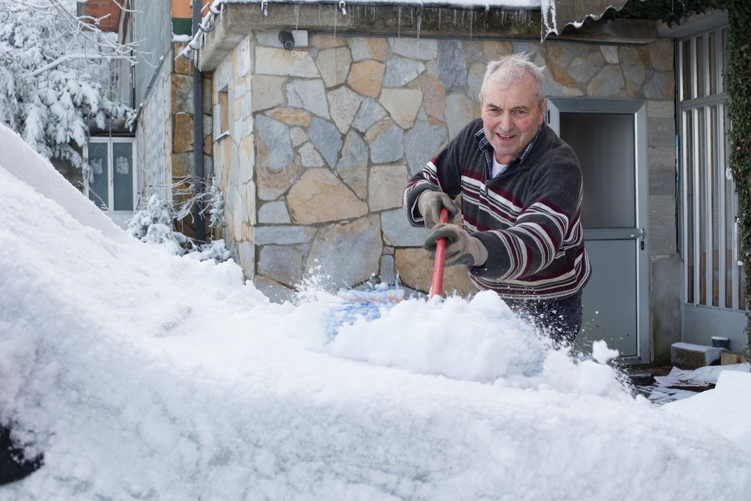 Un vecino de la localidad retira la nieve de su vehículo, en el municipio de  Pedrafita do Cebreiro, en Lugo-País Vasco (España), a 17 de diciembre de 2019.