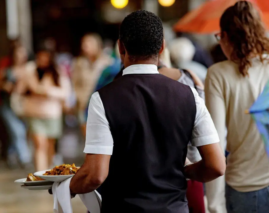 Un camarero porta los platos de los clientes en Madrid.