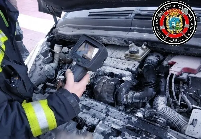 Bomberos de Santander revisan un veh&iacute;culo incendiado