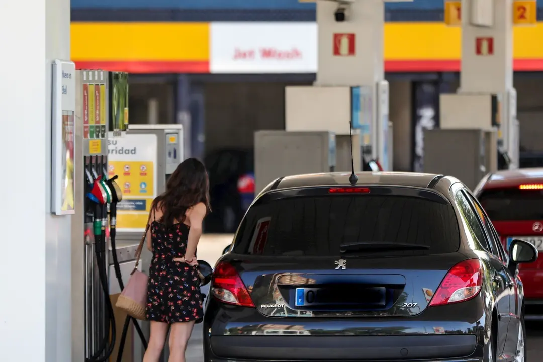 Personas ponen gasolina en sus coches en una gasolinera de Madrid.