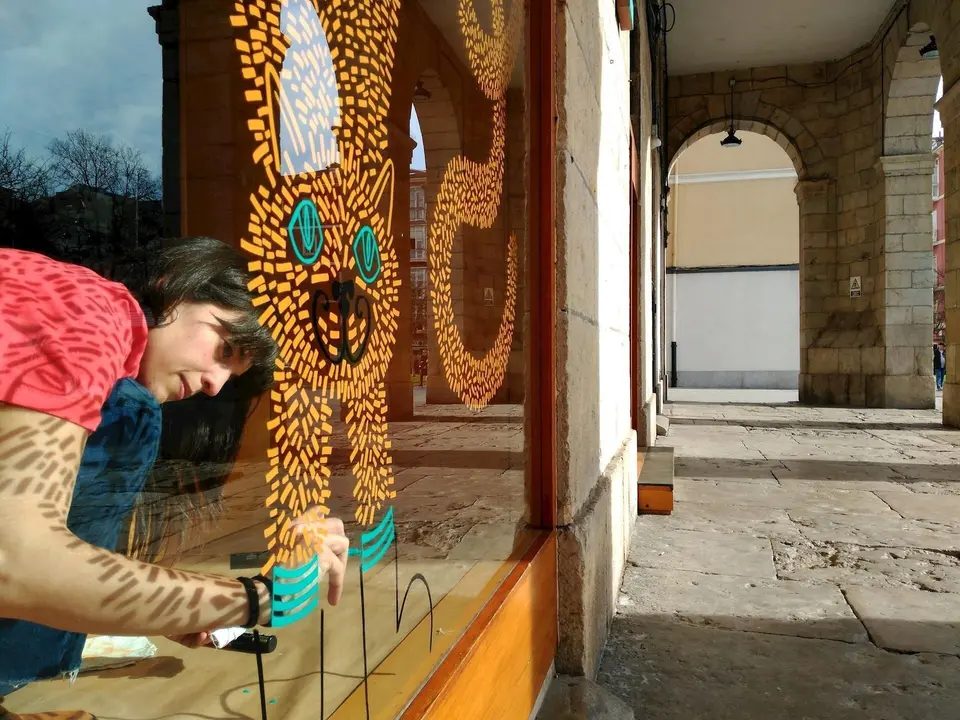 Una alumna de la Escuela de Arte interviene en un escaparate