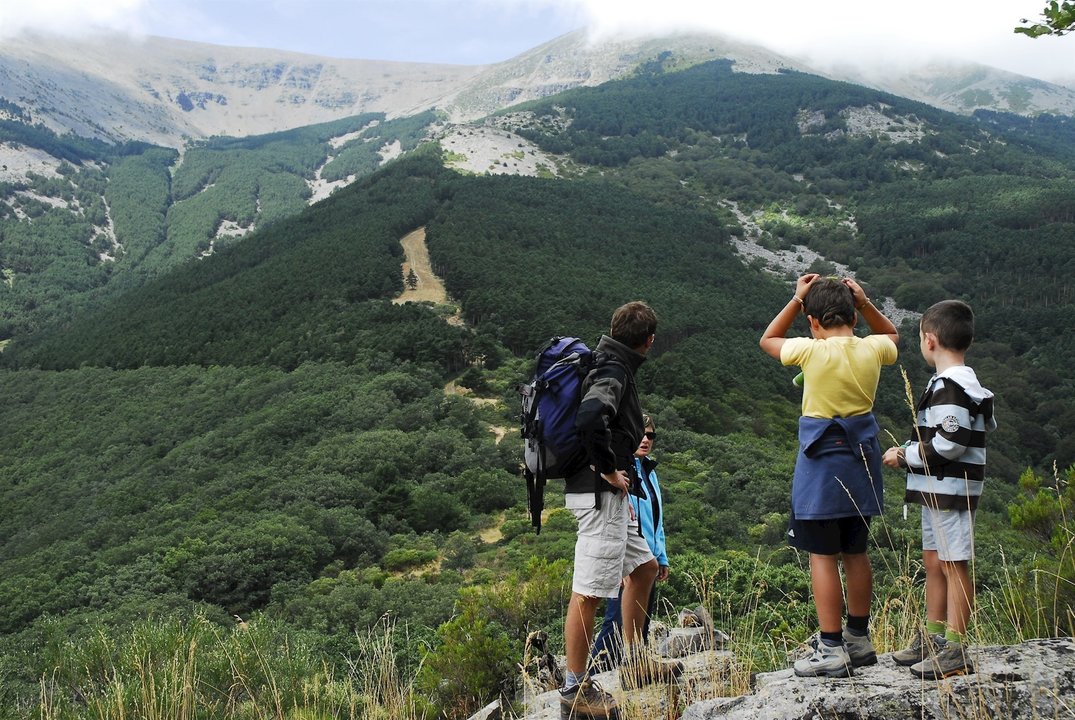 Un guía junto a unos niños en una actividad de senderismo en los Pirineos aragoneses.