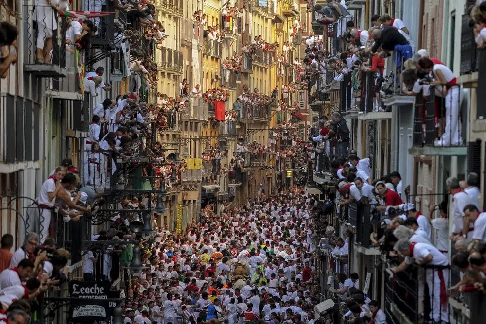 Participants run in front of Alcurrucen's bulls during the first bull run of the San Fermin Festival, on July 7, 2013, in Pamplona, northern Spain. The festival is a symbol of Spanish culture that attracts thousands of tourists to watch the bull runs despite heavy condemnation from animal rights groups. AFP PHOTO/ PEDRO ARMESTRE