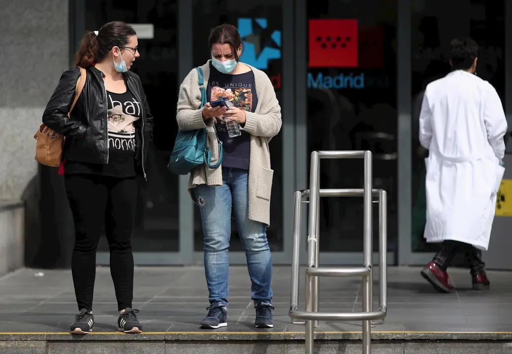 Dos mujeres protegidas con mascarilla a las afueras del Hospital de la Paz donde se ha habilitado un espacio para atender "en mejores condiciones" a pacientes sospechosos de coronavirus, en Madrid (Espa&ntilde;a), a 12 de marzo de 2020.