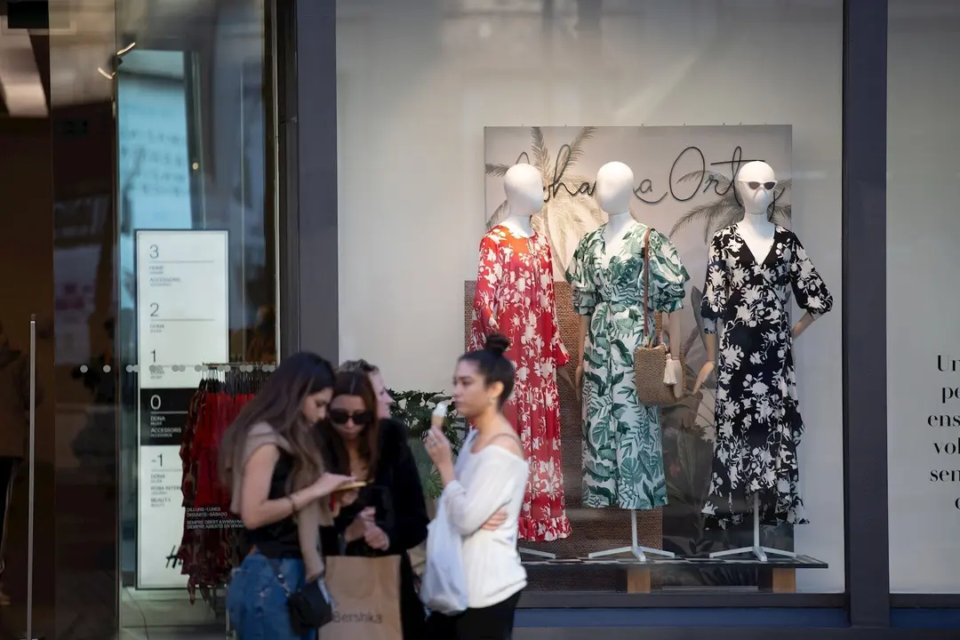 Unas j&oacute;venes con bolsas de la marca Bershka y frente a un establecimiento de la misma cadena en Barcelona el d&iacute;a en que el grupo Inditex (al que pertenece Bershka) ha cerrado sus tiendas en Madrid, La Rioja y Miranda de Ebro. En Barcelona (Catalunya, Espa