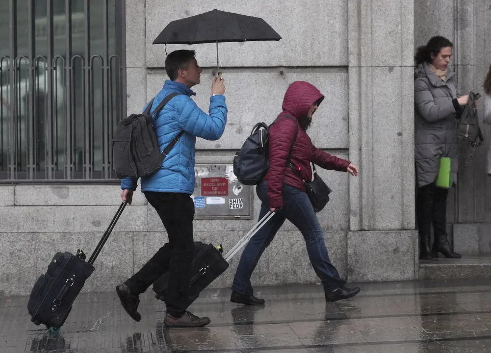 Dos turistas se refugian de la lluvia con paraguas, en Madrid (Espa&ntilde;a), a 5 de marzo de 2020.