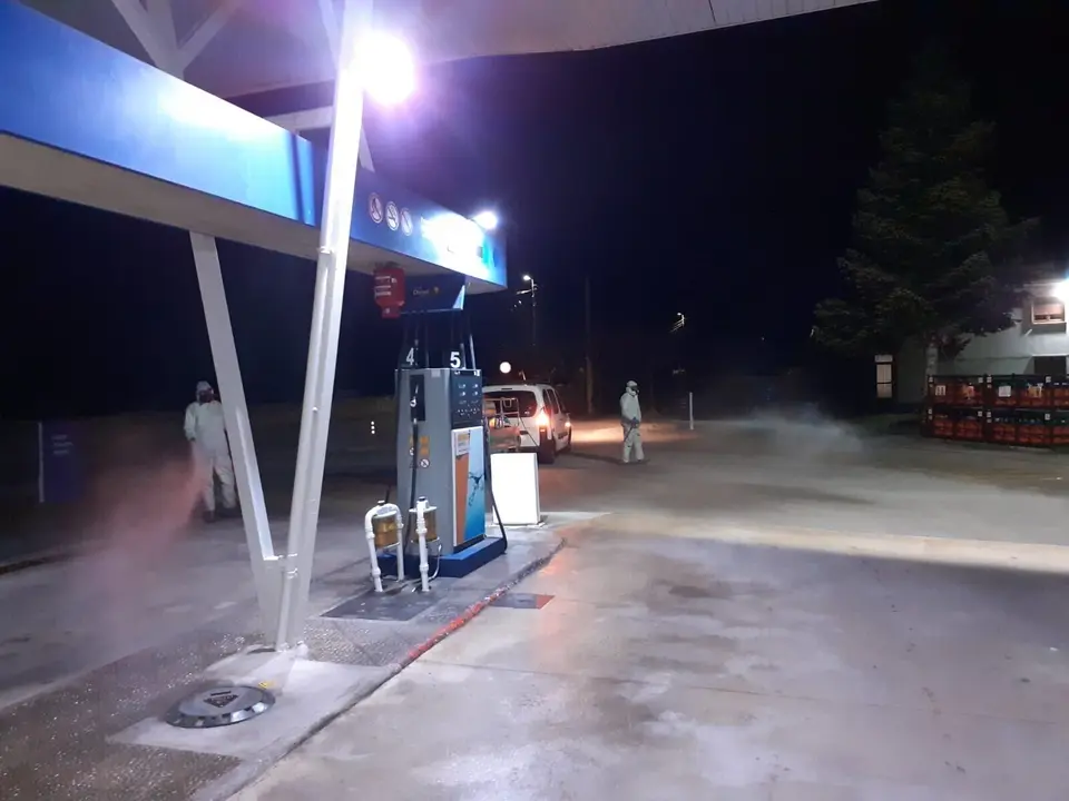 Efectivos del dispositivo regional de desinfecci&oacute;n en una gasolinera