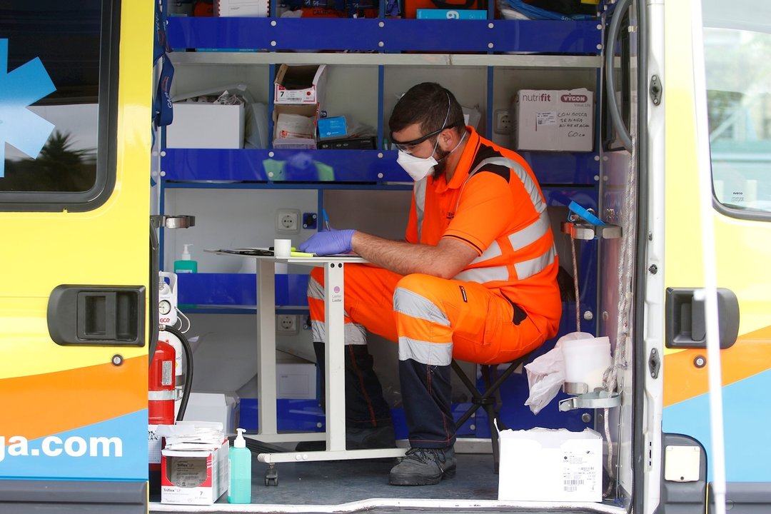 Dispositivo sanitario de la prueba test del PCR para detectar la infección por coronavirus a una persona desde su coche, instalado en el recinto de aparcamineto del centro de salud de la barriada La Roca, en Málaga, (Andalucía, España), 