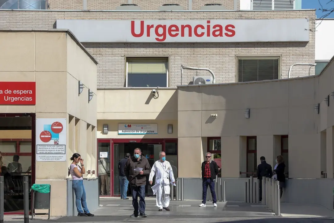 Varias personas protegidas con mascarilla se encuentran cerca de la puerta de Urgencias del Hospital Gregorio Mara&ntilde;&oacute;n (Madrid).