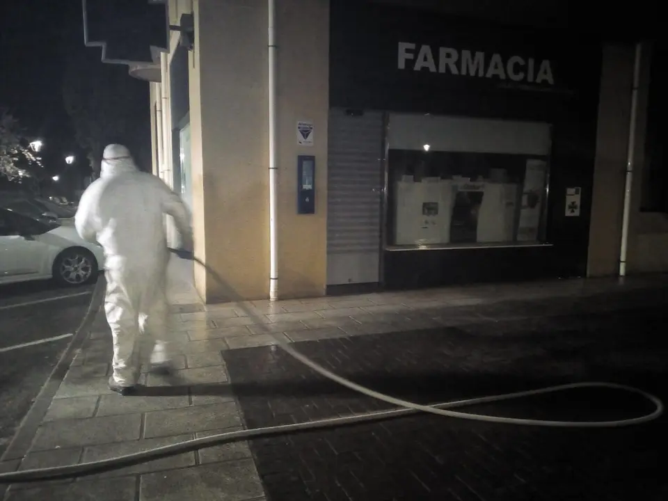 Efectivos del plan de limpieza y desinfecci&oacute;n trabajan en el exterior de una farmacia