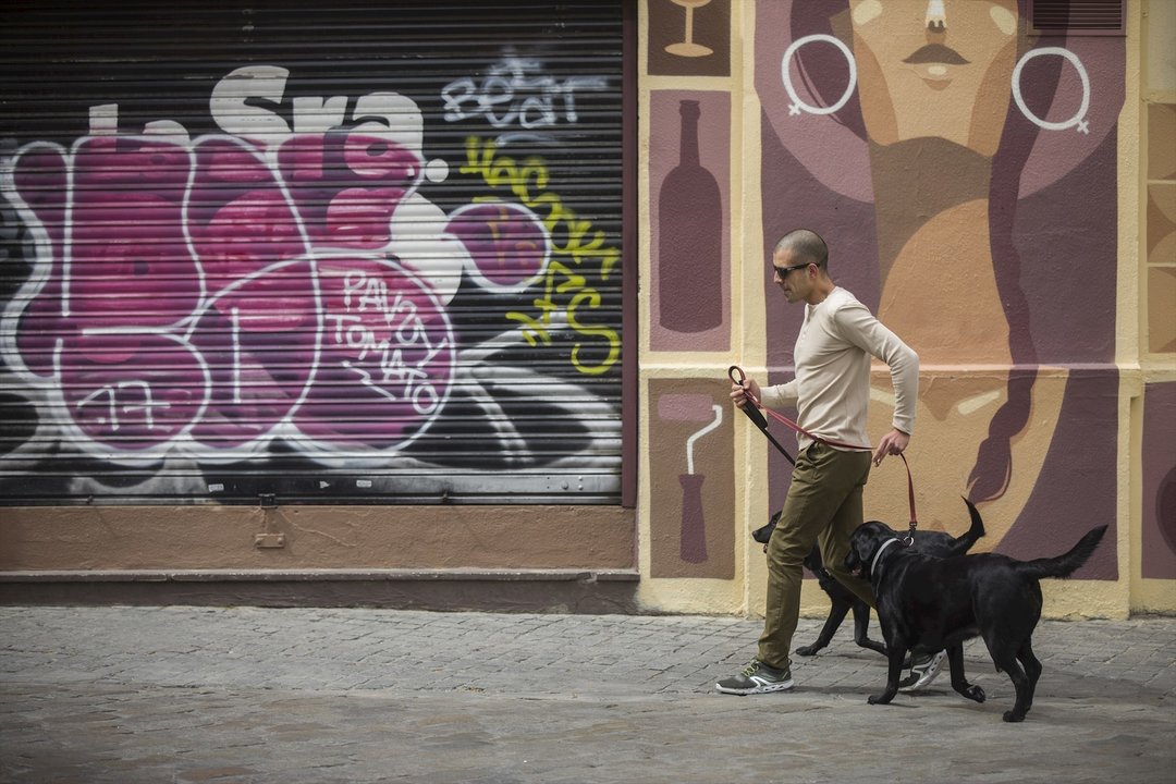 Un hombre pasea a su perro durante confinamiento. Archivo