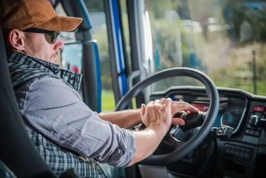 Caucasian Truck Driver in His 30s in the Semi Cabin. Modern Transportation Job.
