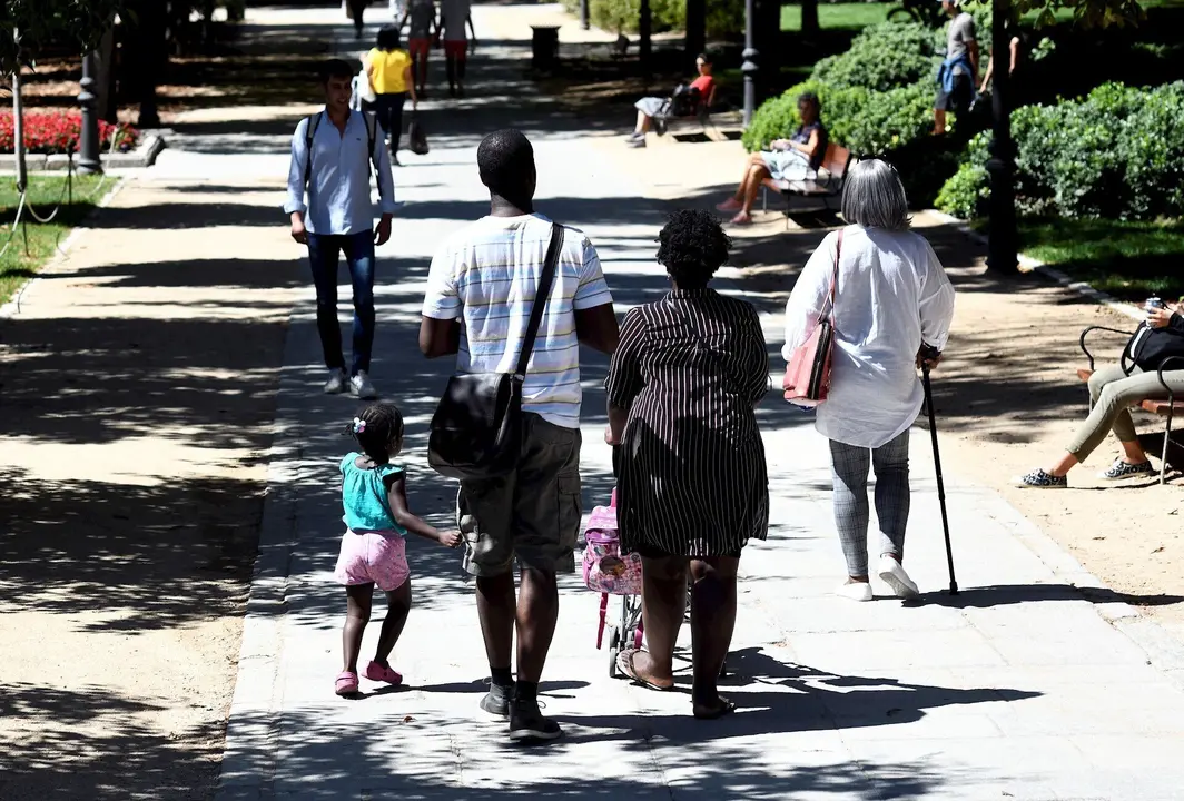 Una familia pasea con su ni&ntilde;a por un parque de Madrid.
