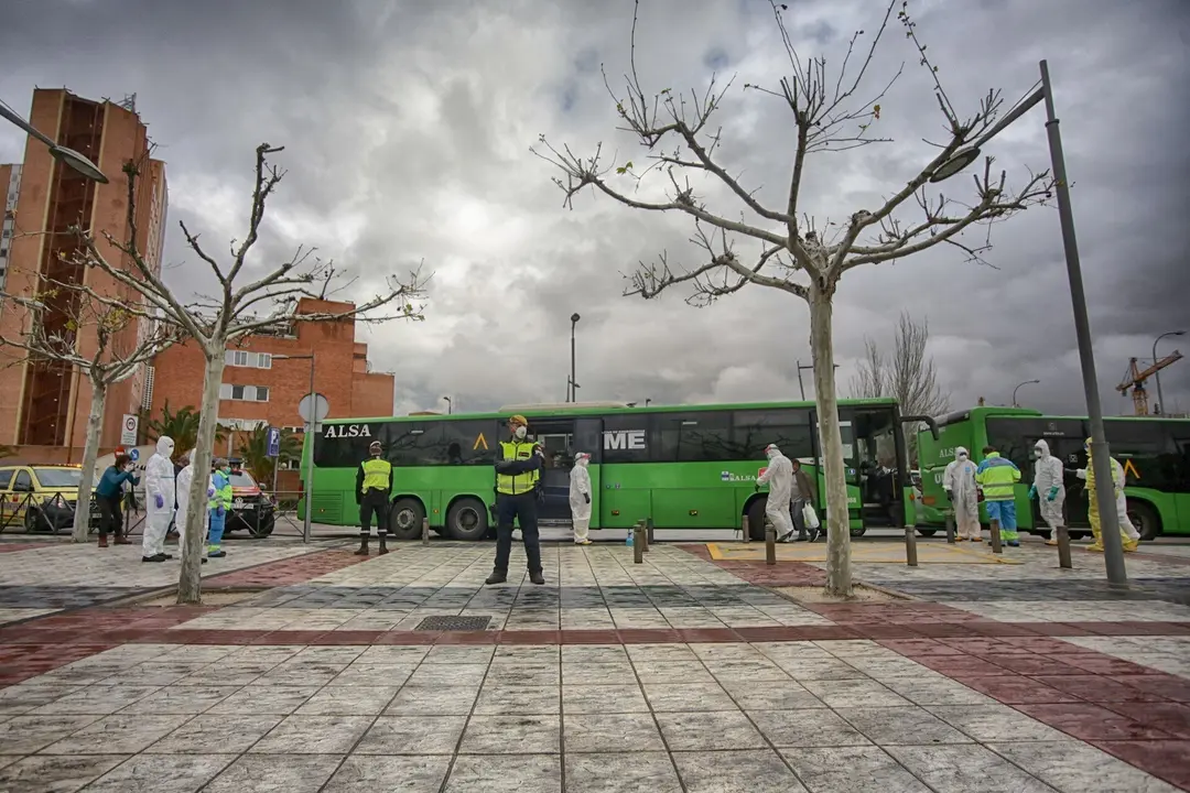 Polic&iacute;as militares escoltan uno de los autobuses cuyos pasajeros son pacientes contagiados con coronavirus