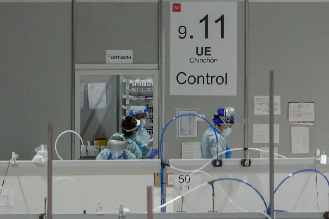 Sanitarios protegidos con mascarillas, gorros y pantallas protectoras en la puerta del almac&eacute;n de material farmac&eacute;utico en el Hospital temporal de la Comunidad de Madrid habilitado en IFEMA para pacientes con coronavirus, en Madrid (Espa&ntilde;a) a 31 de marzo