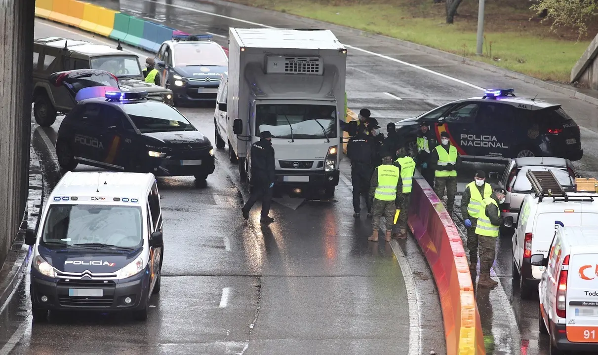 Varios militares del ej&eacute;rcito y polic&iacute;as nacionales efect&uacute;an un control de tr&aacute;fico en la carretera de Alcobendas (Madrid) durante la tercera semana de confinamiento por la crisis del coronavirus