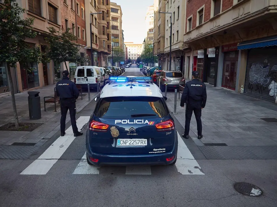 Dos agentes de la Polic&iacute;a Nacional junto a su coche