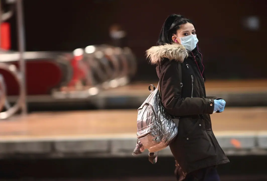 Viajeros esperan en uno de los andenes de Atocha donde la polic&iacute;a est&aacute; entregando mascarillas a los usuarios de transporte p&uacute;blico durante el segundo d&iacute;a de reparto de mascarillas en el transporte p&uacute;blico.