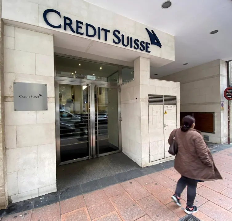 Una mujer pasa junto a la entrada de la sede de Credit Suisse en Madrid (Espa&ntilde;a), a 29 de enero de 2020.