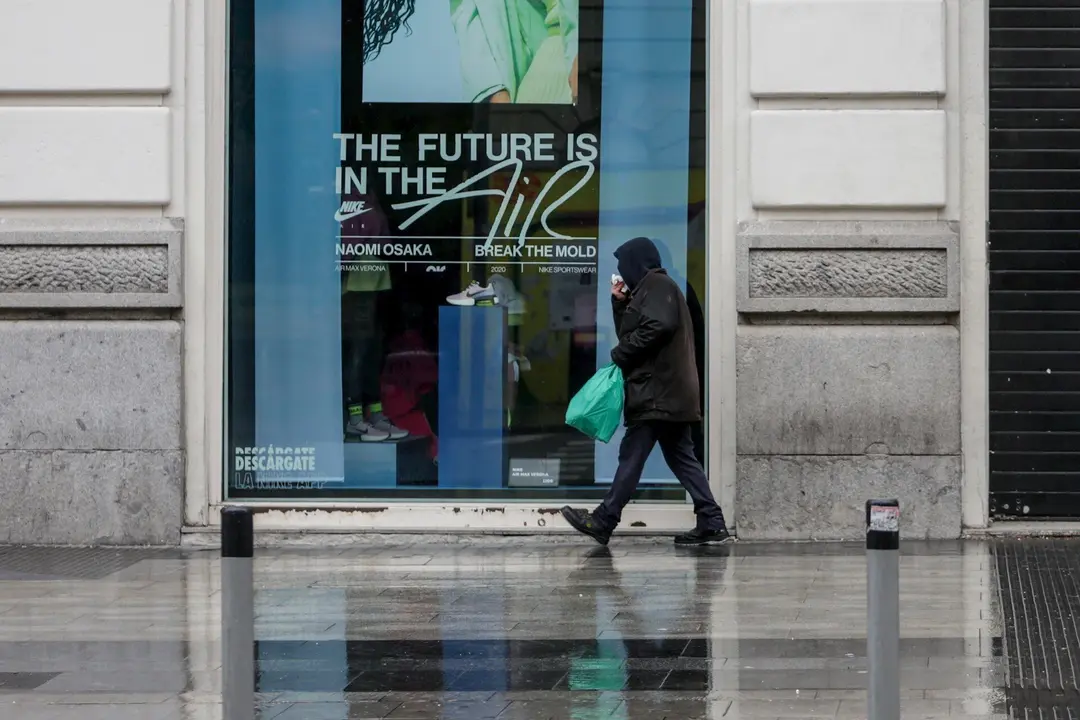 Una persona camina por una calle de Madrid donde las temperaturas han bajado estrepitosamente durante el segundo d&iacute;a de la entrada en vigor de la limitaci&oacute;n total de movimientos salvo de los trabajadores de actividades esenciales, medida adoptada ayer por