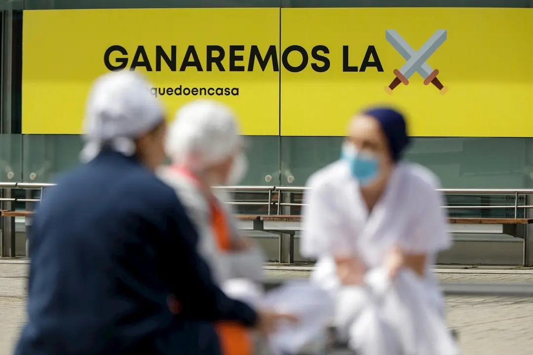 Sanitarios junto a un cartel en el que se lee 'Ganaremos la batalla' en el hospital de campa&ntilde;a de IFEMA, en el que los pacientes de coronavirus son ahora atendidos &uacute;nicamente en el Pabell&oacute;n 9 tras el cierre del 7 al bajar la presi&oacute;n asistencial y que esta