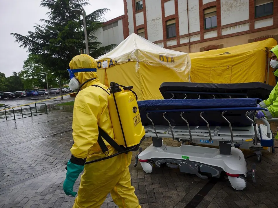 Voluntarios de la asociaci&oacute;n sin &aacute;nimo de lucro DYA desinfectan bajo la lluvia camillas en las inmediaciones del Complejo Hospitalario de Navarra prevenir la expansi&oacute;n del coronavirus. En Pamplona, (Navarra), a 21 de abril de 2020.