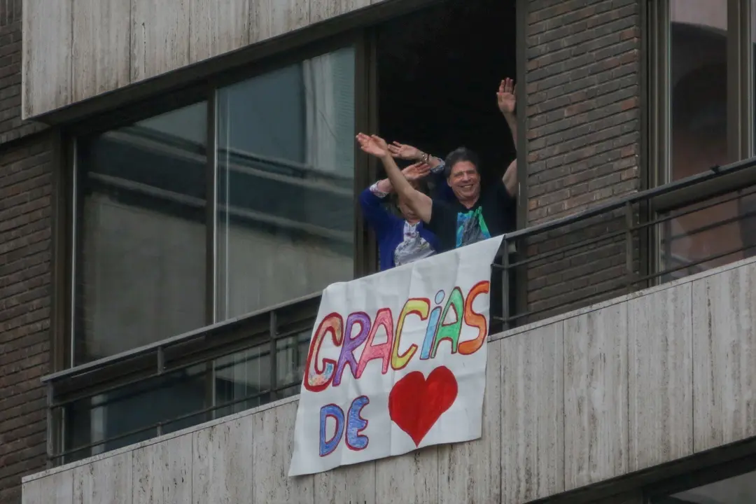 Dos vecinas sacan una pancarta en su casa como muestra de agradecimiento al personal sanitario que trabaja a destajo en la crisis del coronavirus  
