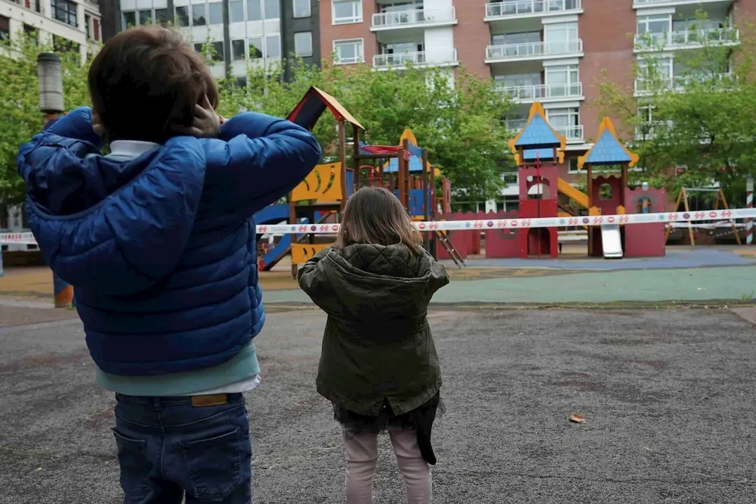 Un ni&ntilde;o y una ni&ntilde;a frente a un parque infantil clausurado, el primer d&iacute;a en el que los menores de 14 a&ntilde;os pueden salir a la calle, en Bilbao (Pa&iacute;s Vasco/Espa&ntilde;a) a 26 de abril de 2020.