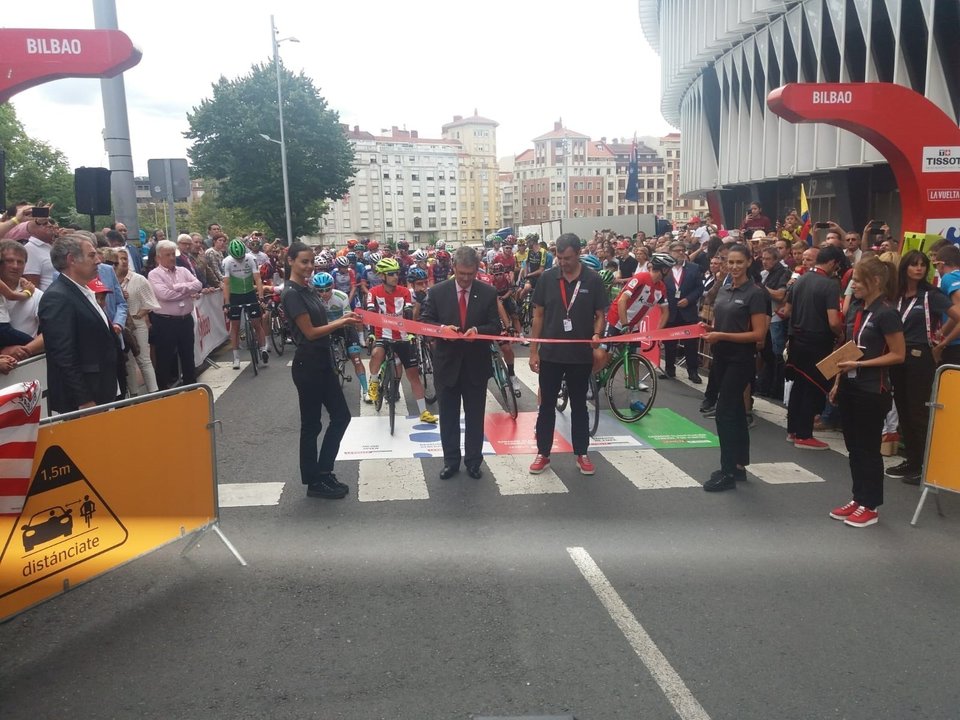 El alcalde de Bilbao, Juan Mari Aburto, corta la cinta para dar inicio a la decimotercera etapa de la Vuelta 2019 desde los alrededores del estadio San Mamés