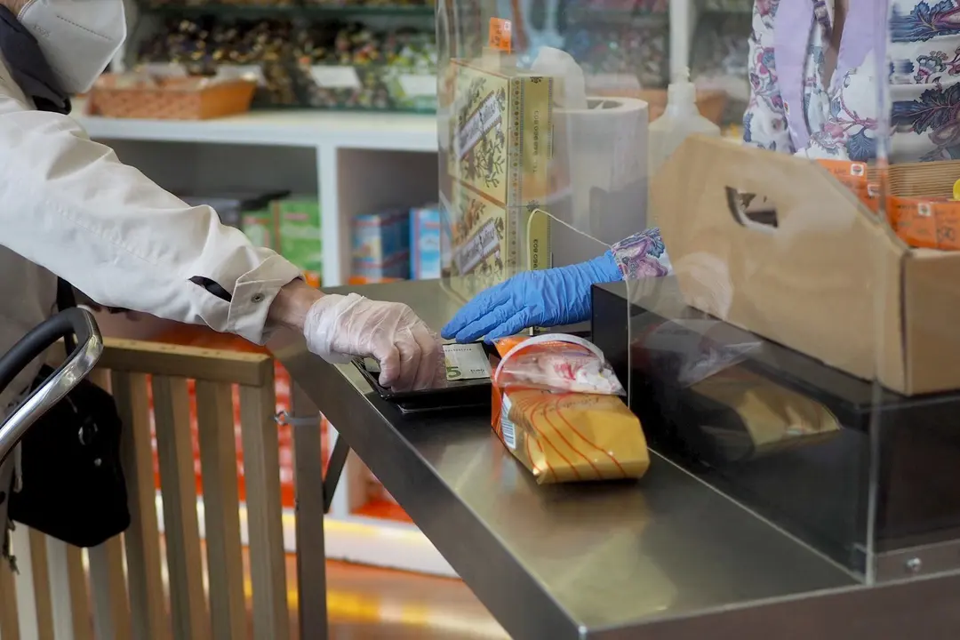 Una persona es atendida por una trabajadora de una farmacia de Vitoria, durante el d&iacute;a 46 de estado de alarma por la crisis del Covid-19, donde los movimientos est&aacute;n permitidos tan solo a menores de 14 a&ntilde;os, personas que no puedan teletrabajar o todos aqu