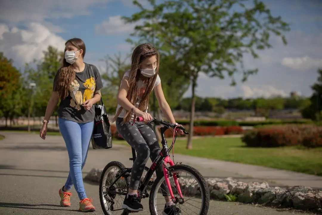 Una mujer con su hija pasean por el parque en el tercer d&iacute;a de desconfinamiento de ni&ntilde;os y preadolescentes. En Sevilla (Andaluc&iacute;a, Espa&ntilde;a), a 28 de abril de 2020