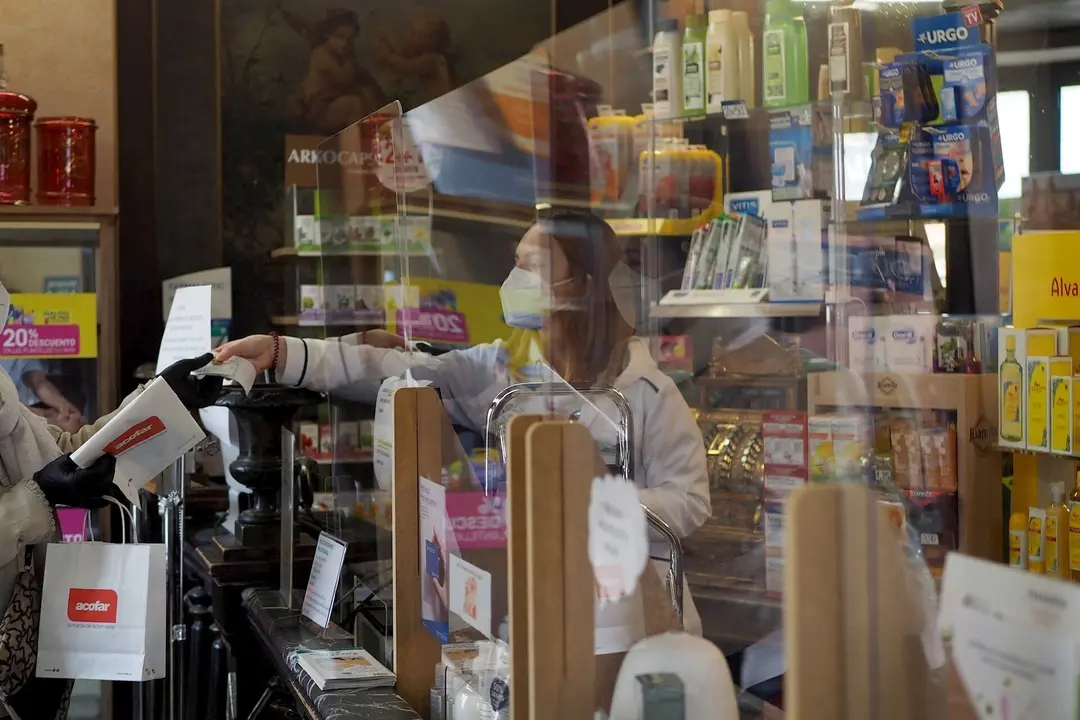 Una persona es atendida por una trabajadora de una farmacia de Vitoria, durante el d&iacute;a 46 de estado de alarma por la crisis del Covid-19, donde los movimientos est&aacute;n permitidos tan solo a menores de 14 a&ntilde;os, personas que no puedan teletrabajar o todos aqu