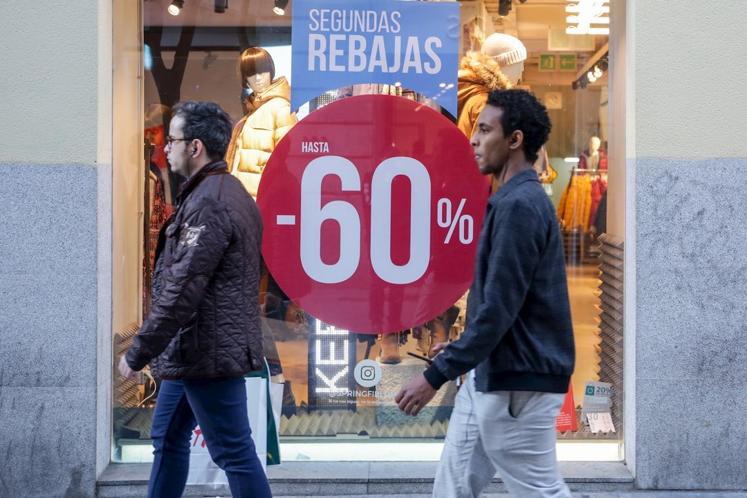 Dos hombres pasean junto a una tienda de moda de Madrid