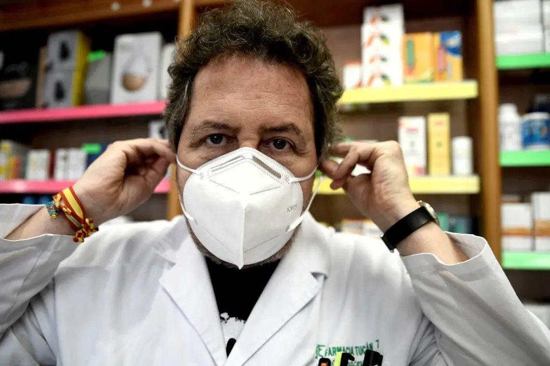 Un farmac&eacute;utico se coloca una de las siete millones de mascarillas FFP2 modelo KN95 que a partir de hoy las farmacias reparten gratuitamente entre la poblaci&oacute;n de la Comunidad de Madrid. En Madrid (Espa&ntilde;a), a 11 de mayo de 2020.