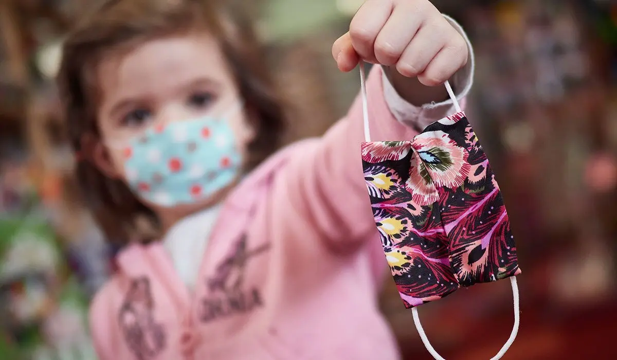 EuropaPress_2915858_nina_muestra_mascarilla_infantil_mientras_sale_calle_primer_dia