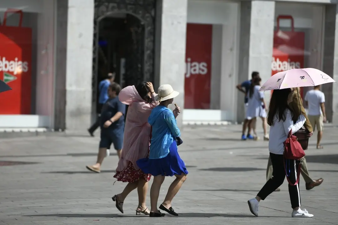 Turistas caminado en un d&iacute;a soleado en el centro de Madrid