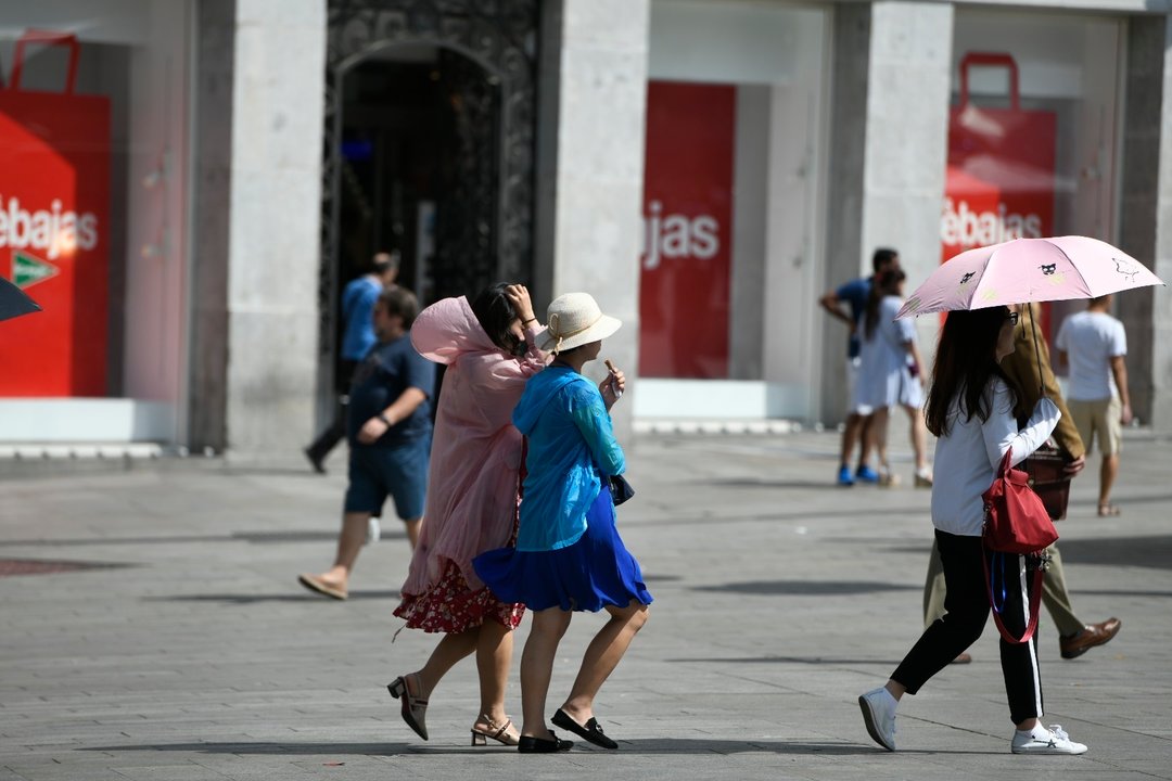 Turistas caminado en un día soleado en el centro de Madrid